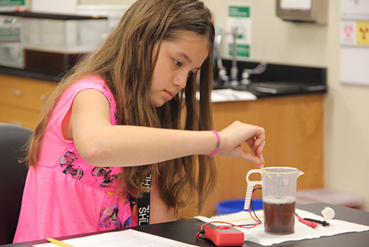 Image of a young student conducting a lab experiment.